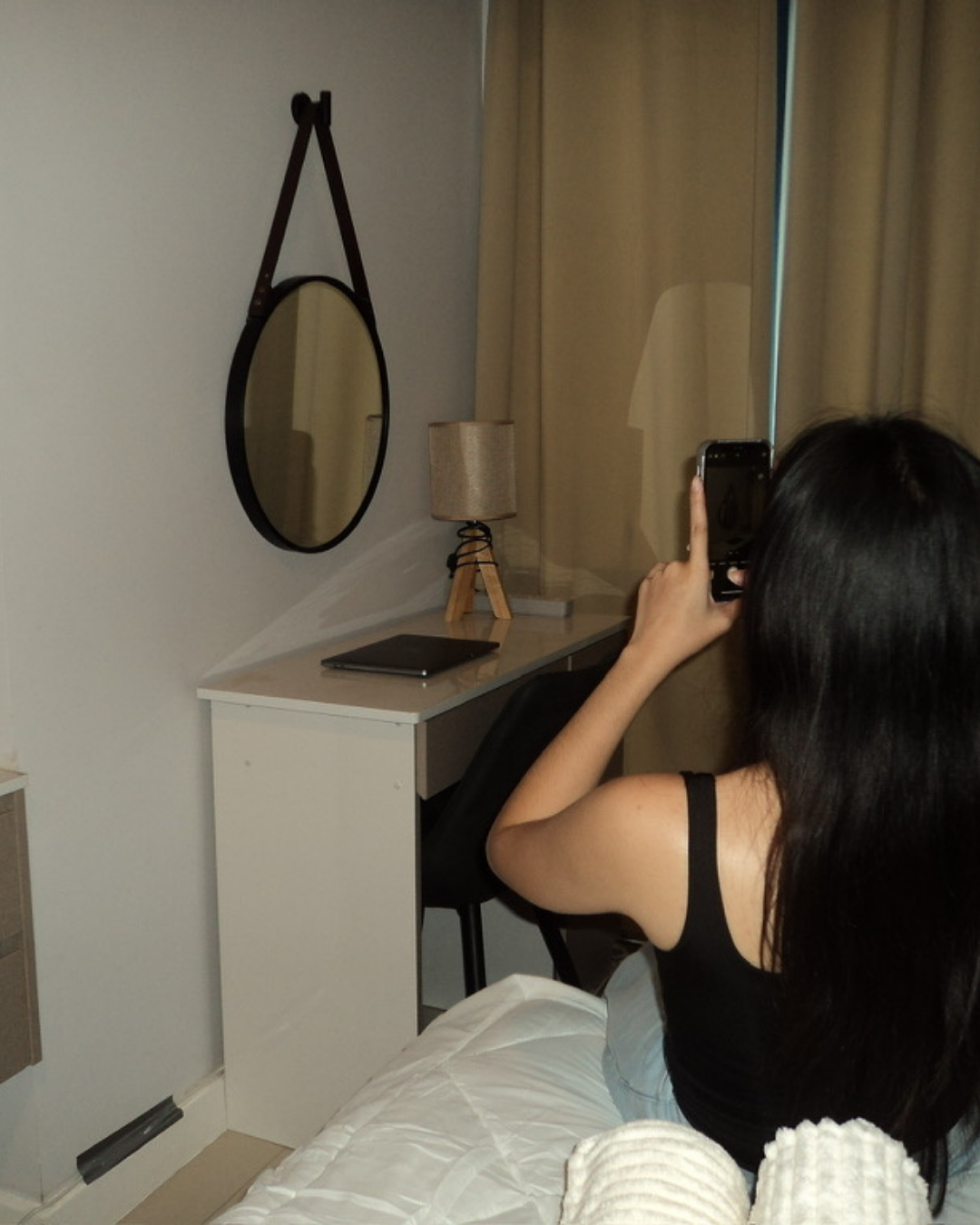 Guest taking a photo in the Avenue Suite mirror by the workspace desk