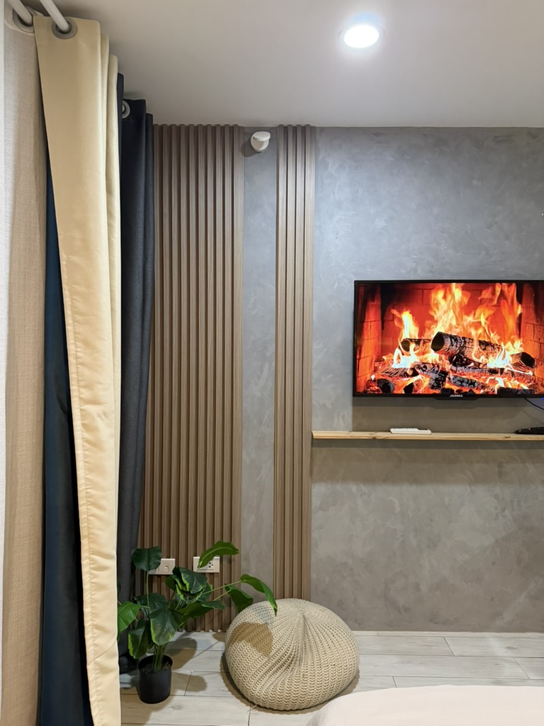 Living area at Cityscape Grand Tower with wall-mounted smart TV and neutral textured finishes