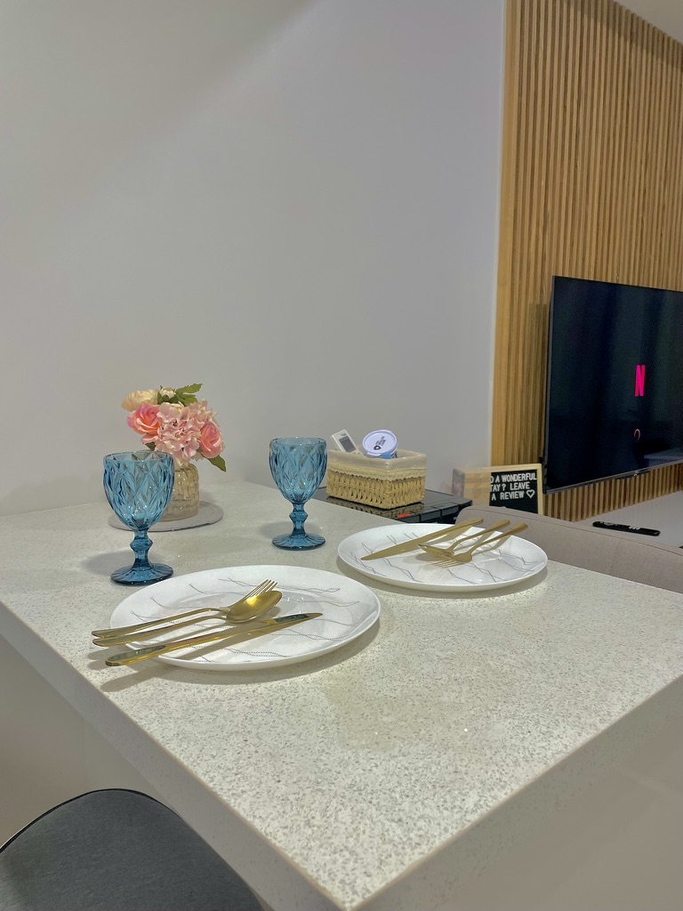 Dining counter at 38 Park Avenue set with plates, gold cutlery and glassware