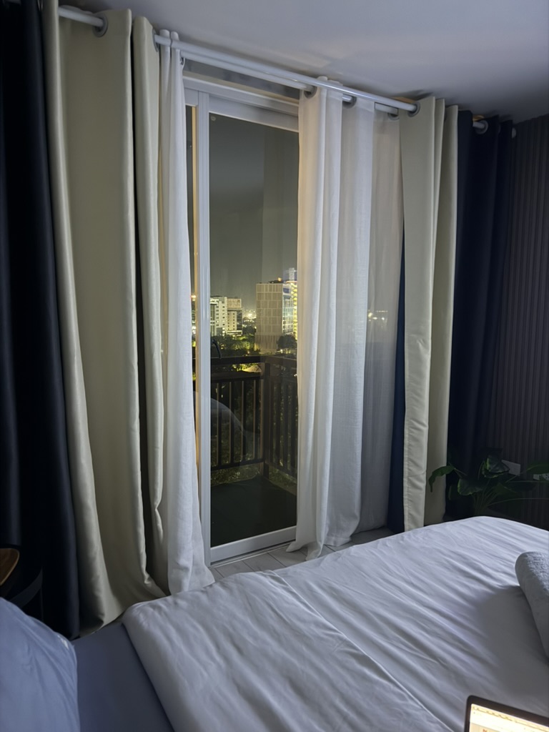 Bedroom at Cityscape Grand Tower with balcony doors open to the Cebu city lights at night