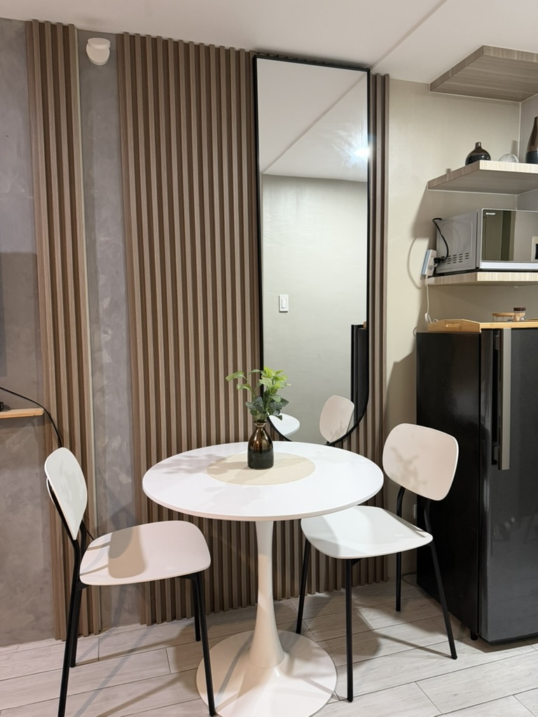 Dining nook at Cityscape Grand Tower with a round white table and refrigerator in view